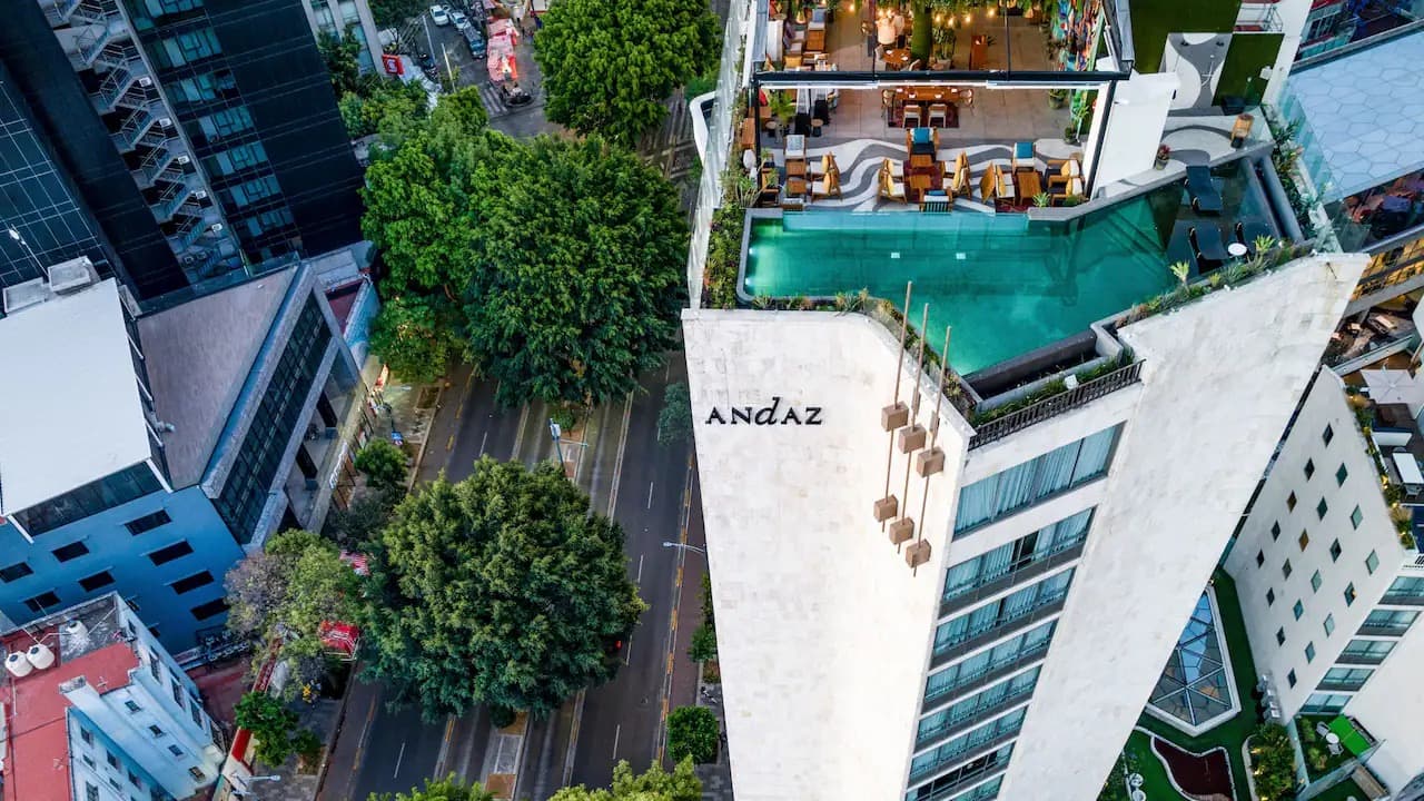 Aerial view of the Andaz rooftop pool and bar above the tree-lined streets of Condesa